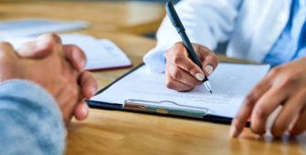 Closeup shot of a doctor writing notes during a consultation with a patient